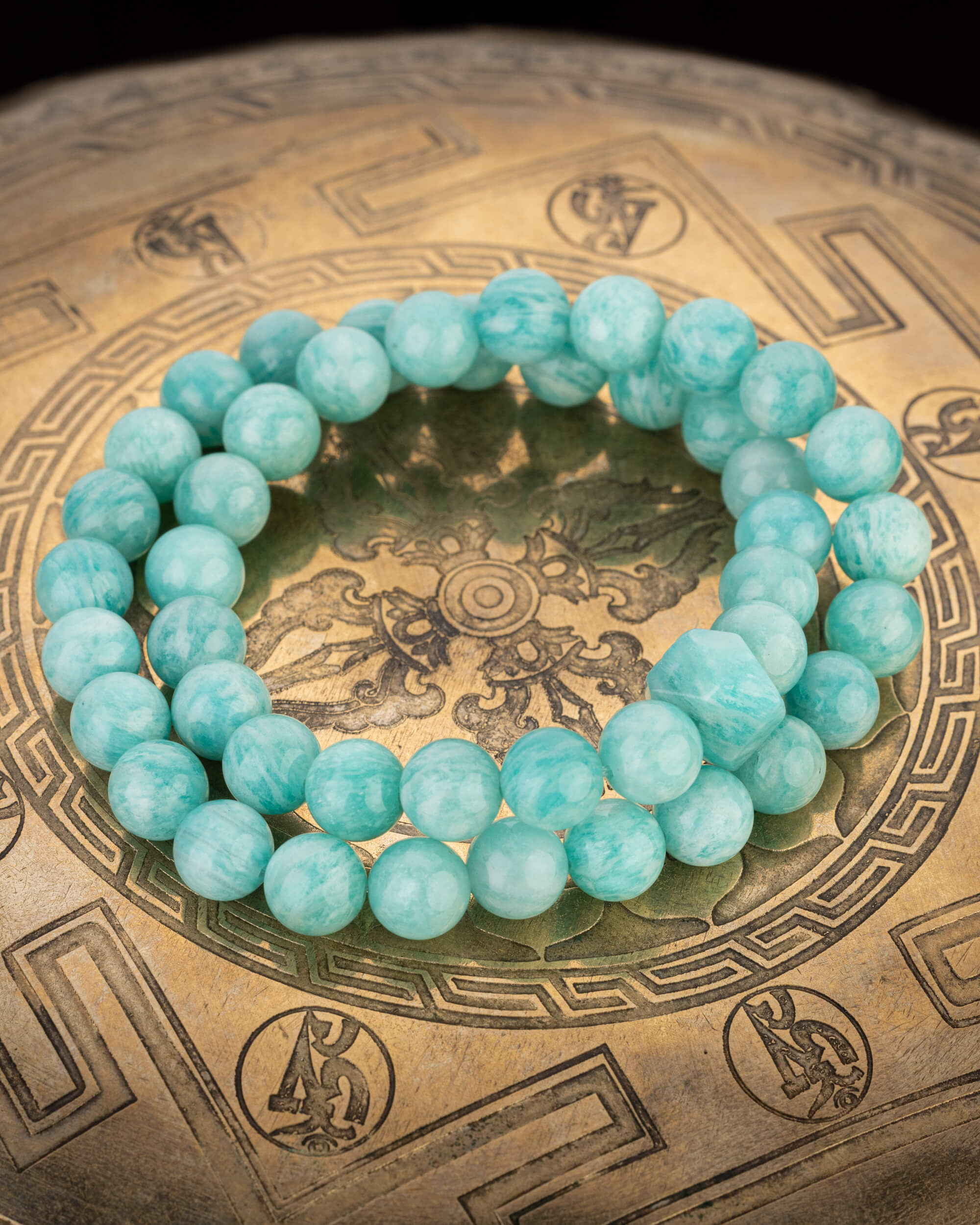 Codificador de Amazonita Aqua completo, en forma circular sobre un cuenco tibetano de bronce