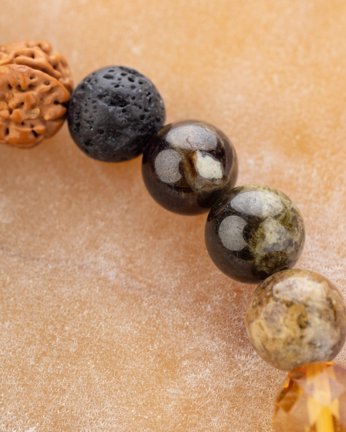 Detalle macro de la Semilla de Rudraksha con Piedra Volcánica y Granate Grosularia
