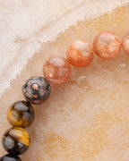 Detalle macro de las cuentas de Piedra Sol Naranja junto a Jaspe Piel de Leopardo y Ojo de Tigre