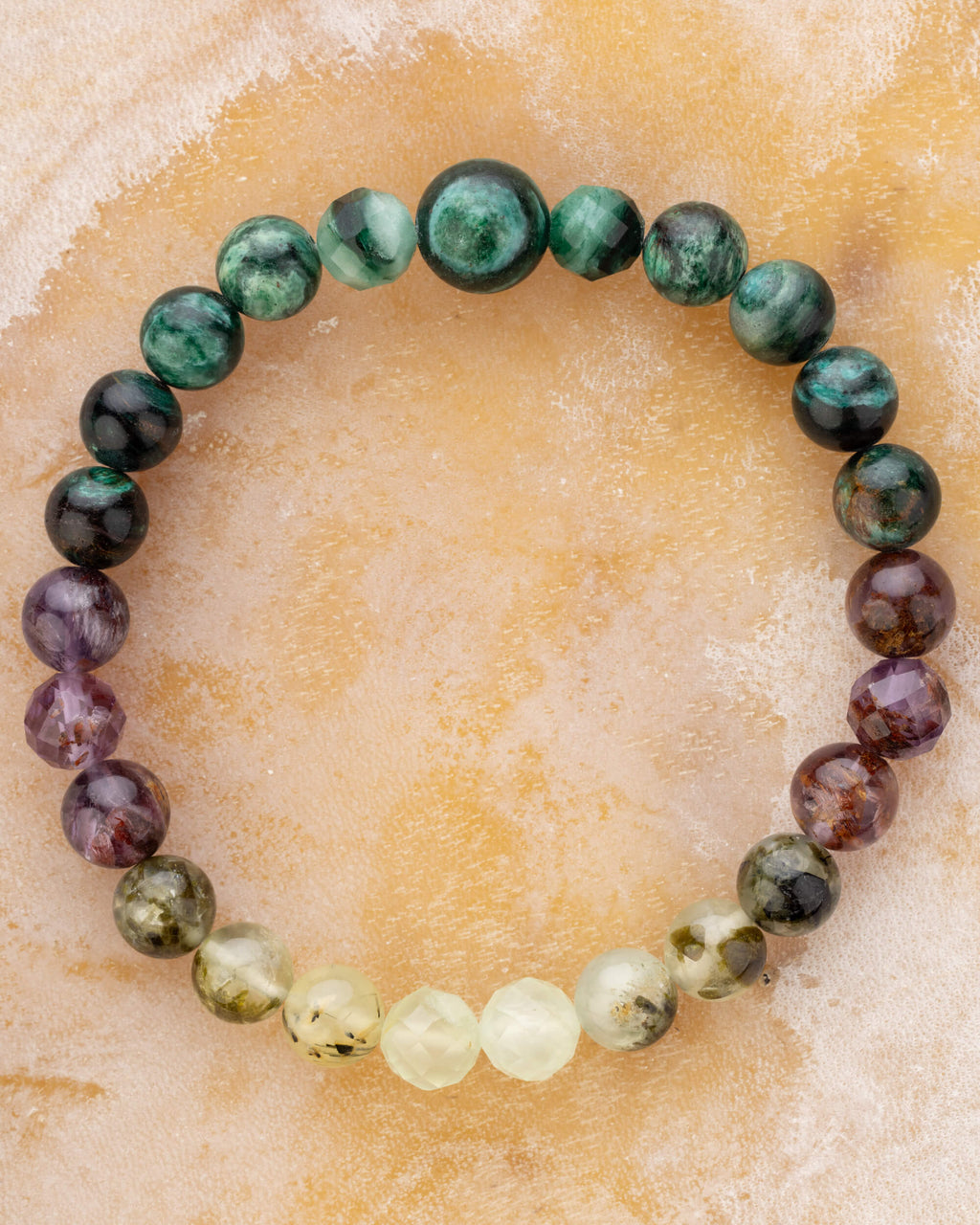 Pulsera zodiacal Escorpio de 8 mm con Esmeralda en Matriz de Biotita, Amatista Fantasma y Prehnita, sobre superficie clara