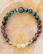 Pulsera zodiacal Escorpio de 8 mm con Esmeralda en Matriz de Biotita, Amatista Fantasma y Prehnita, sobre superficie clara