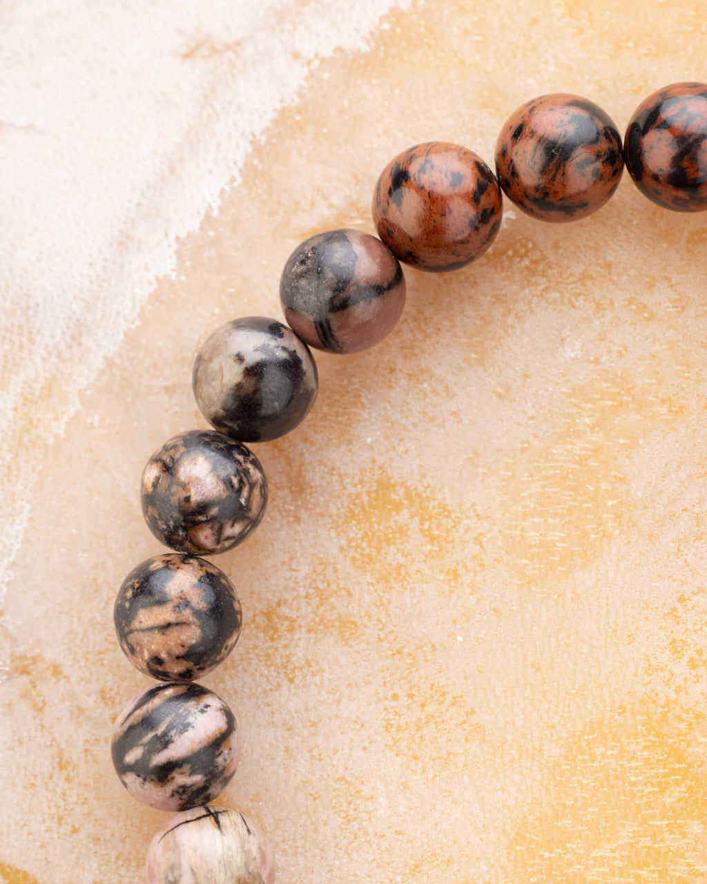 Detalle macro de las cuentas de Obsidiana Caoba y Feldespato Sódico de la pulsera Sagitario