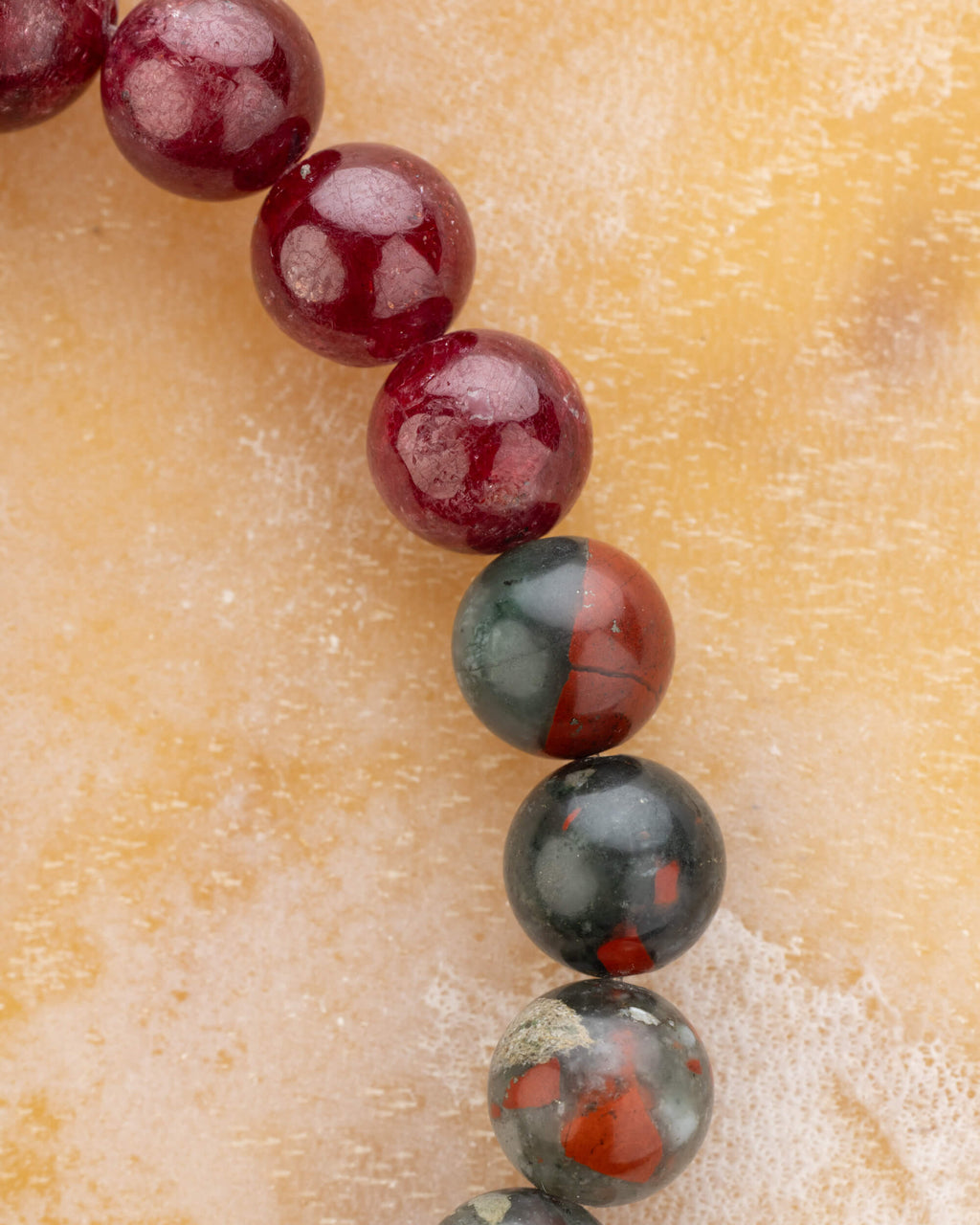 Detalle macro de las cuentas de Rubí y Piedra Sangre de la pulsera Capricornio