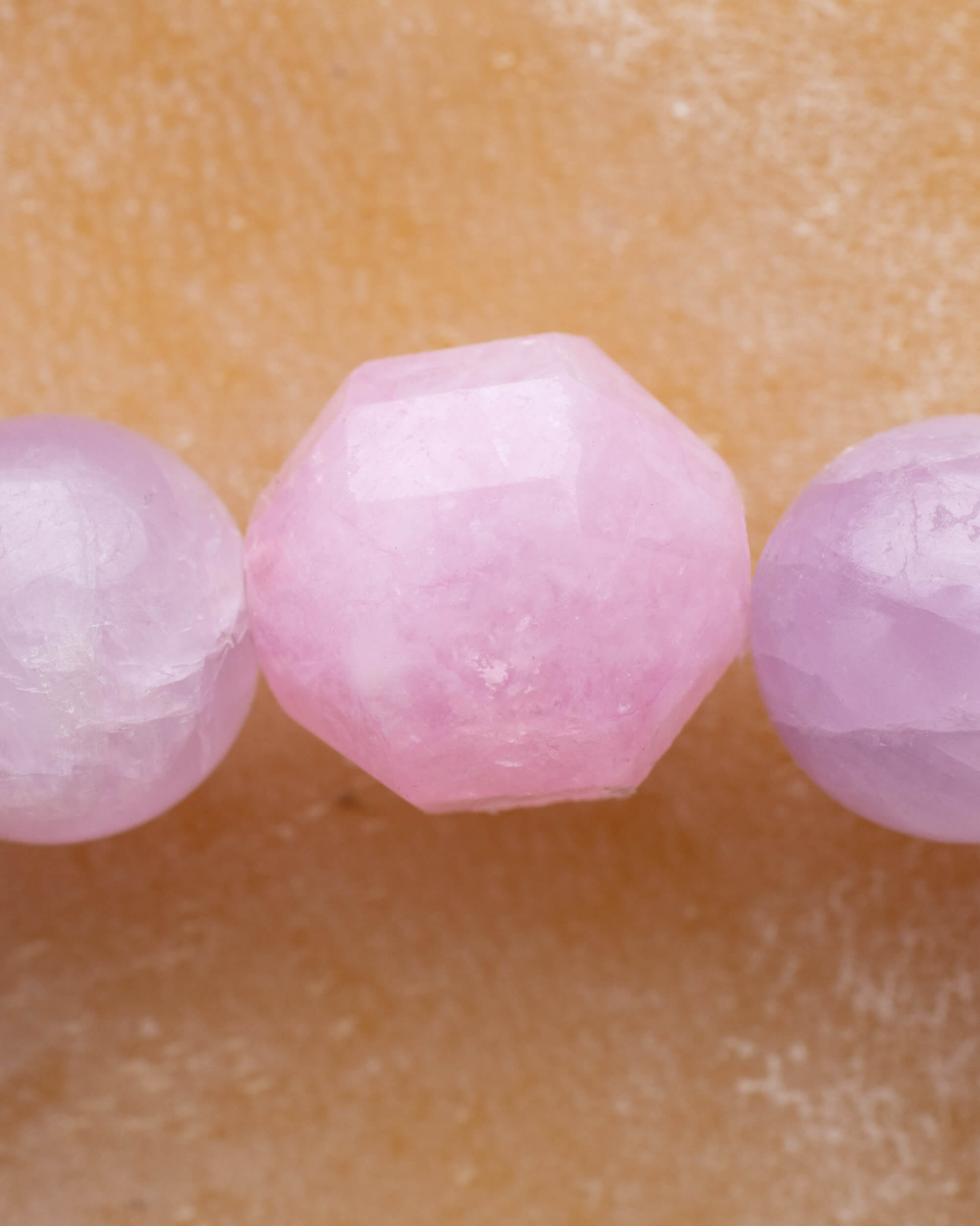 Detalle macro de las cuentas facetadas de Kunzita de la pulsera Piscis