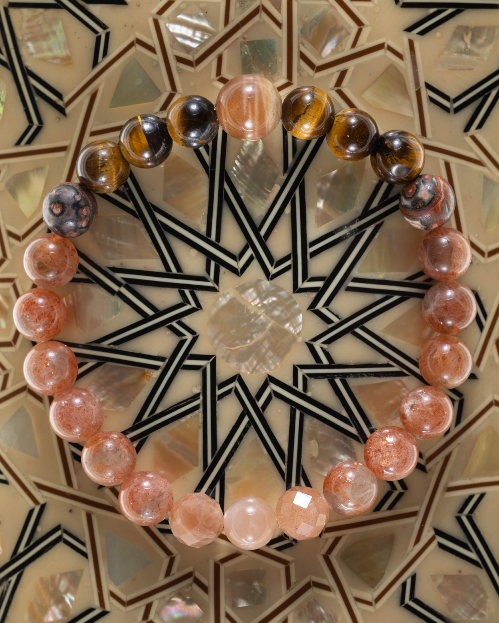 Pulsera zodiacal Leo, pieza completa sobre mosaico decorativo con estrella geometrica