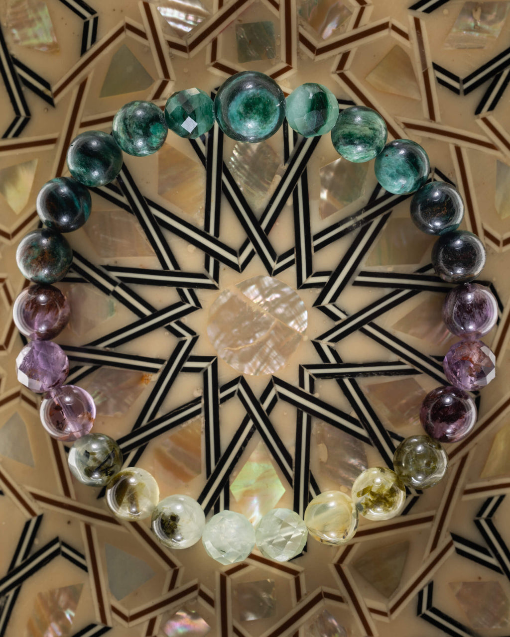Pulsera zodiacal Escorpio, pieza completa sobre mosaico decorativo con estrella geometrica