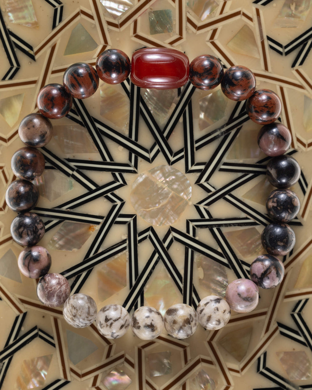 Pulsera zodiacal Sagitario, pieza completa sobre mosaico decorativo con estrella geometrica