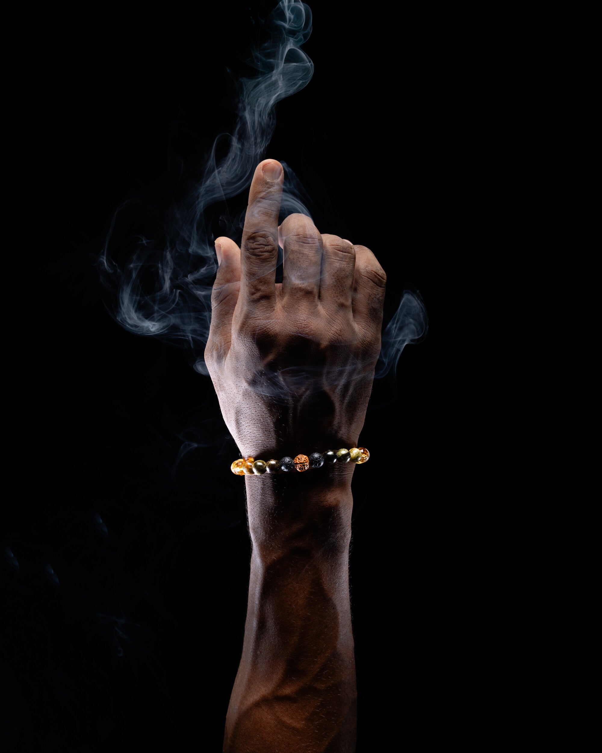 Pulsera Zodiacal Aries puesta en la muñeca, entre volutas de humo