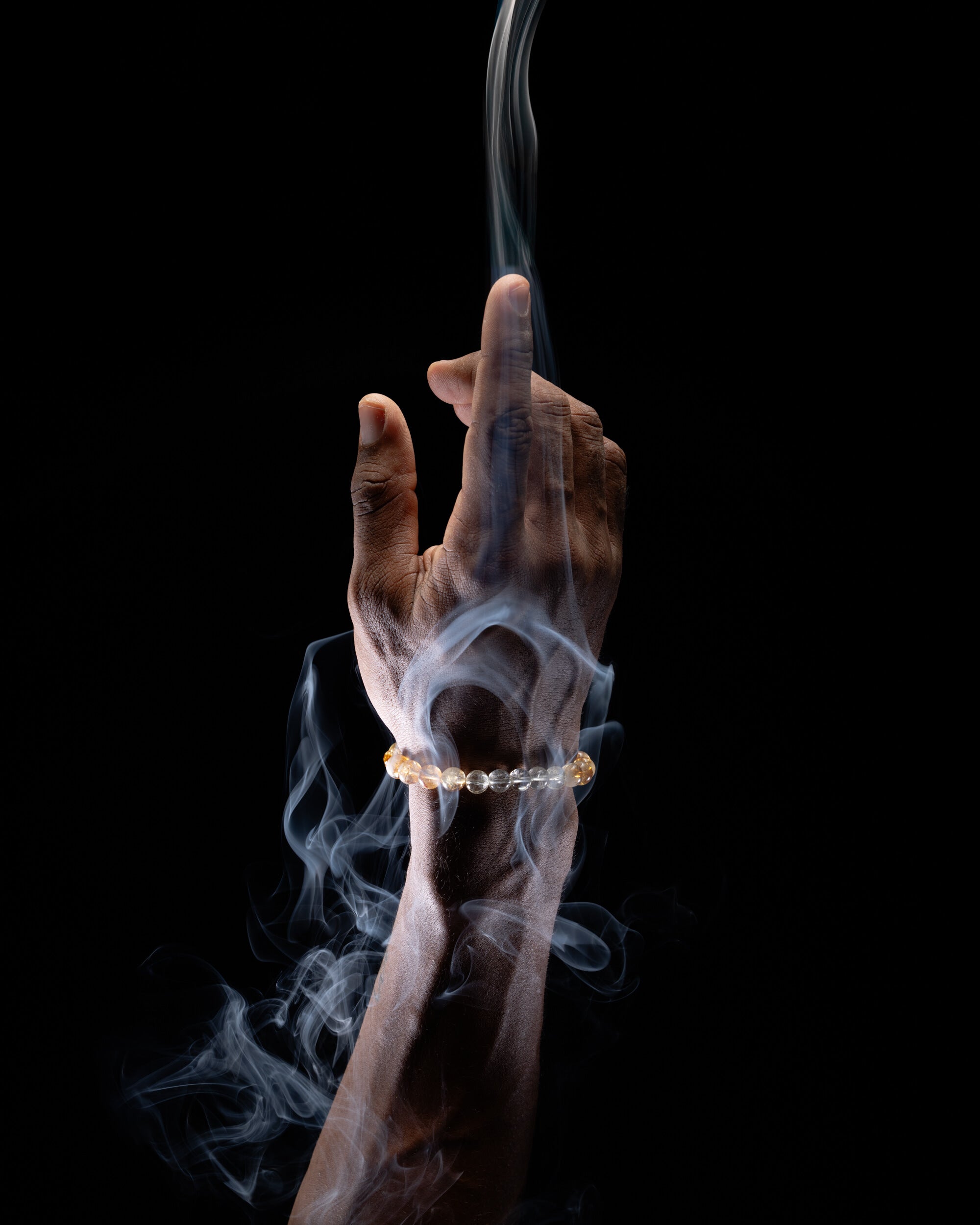 Pulsera Zodiacal Aries puesta en la muñeca, otro ángulo entre humo