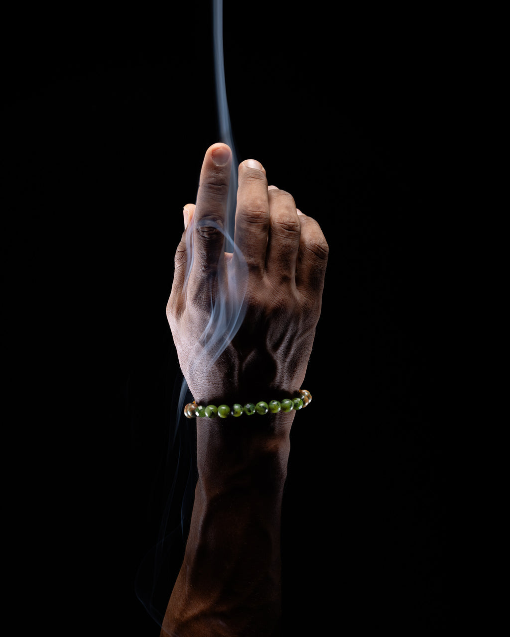 Pulsera Zodiacal Tauro puesta en la muñeca, otro ángulo entre humo