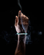 Pulsera Zodiacal Cáncer puesta en la muñeca, otro ángulo entre humo