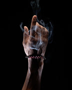 Pulsera zodiacal Virgo puesta en la muñeca, con humo de copal alrededor