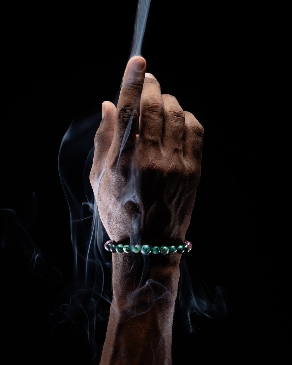 Pulsera zodiacal Escorpio puesta en la muñeca, con humo de copal alrededor