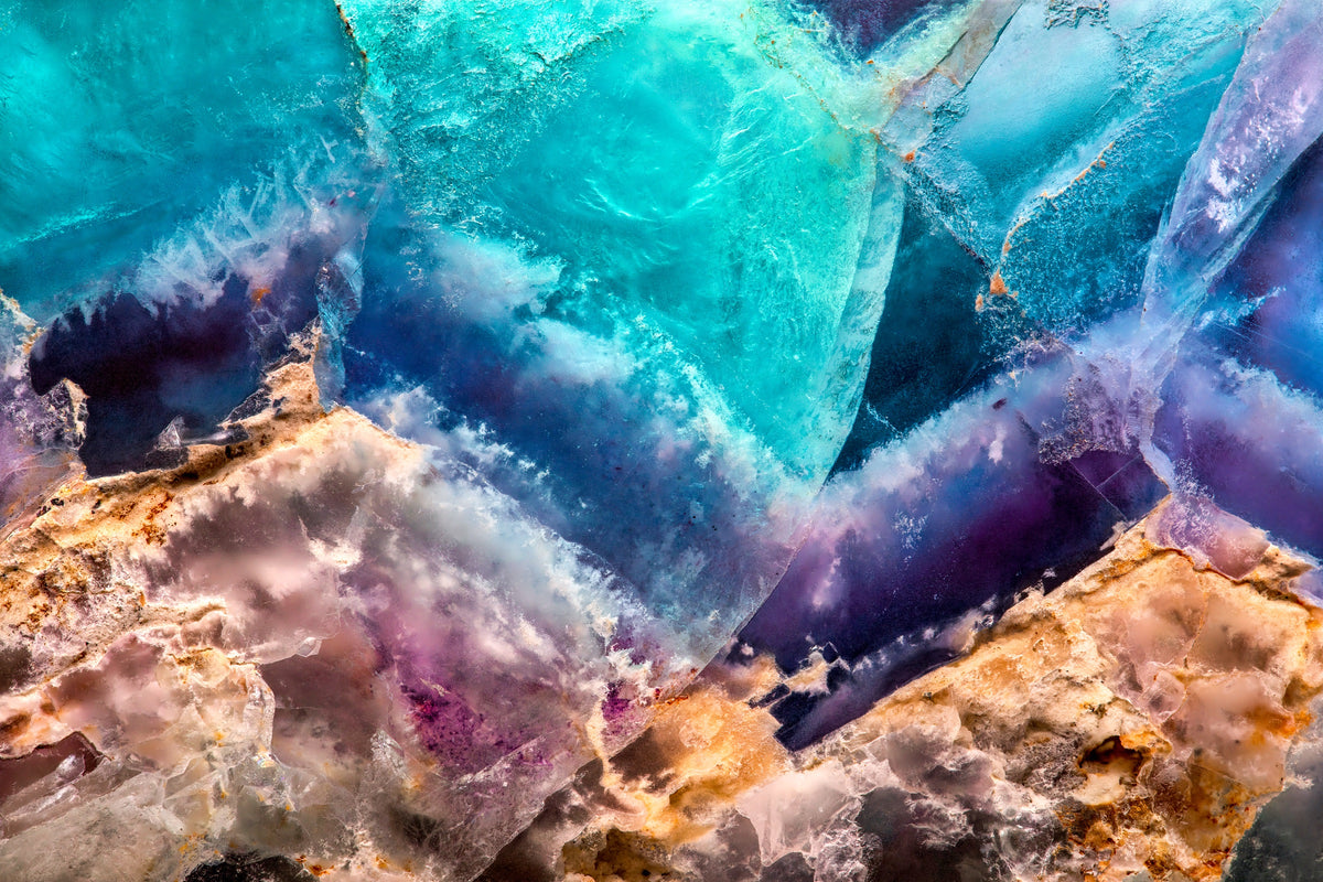 Fotografía macro de la Fluorita: masas turquesa, azul y violeta traslúcidas sobre una matriz ocre y blanca. Serie La Disolución, cuadro 01.