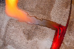 Fotografía macro de la Madera Petrificada: un corte poroso en beige atravesado por una veta de ágata naranja y roja. Serie La Disolución, cuadro 02.