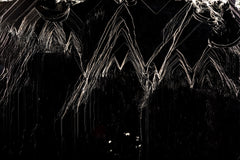 Fotografía macro de la Pirita Espejo: líneas doradas en zigzag sobre negro, las caras estriadas a contraluz. Serie La Disolución, cuadro 17.