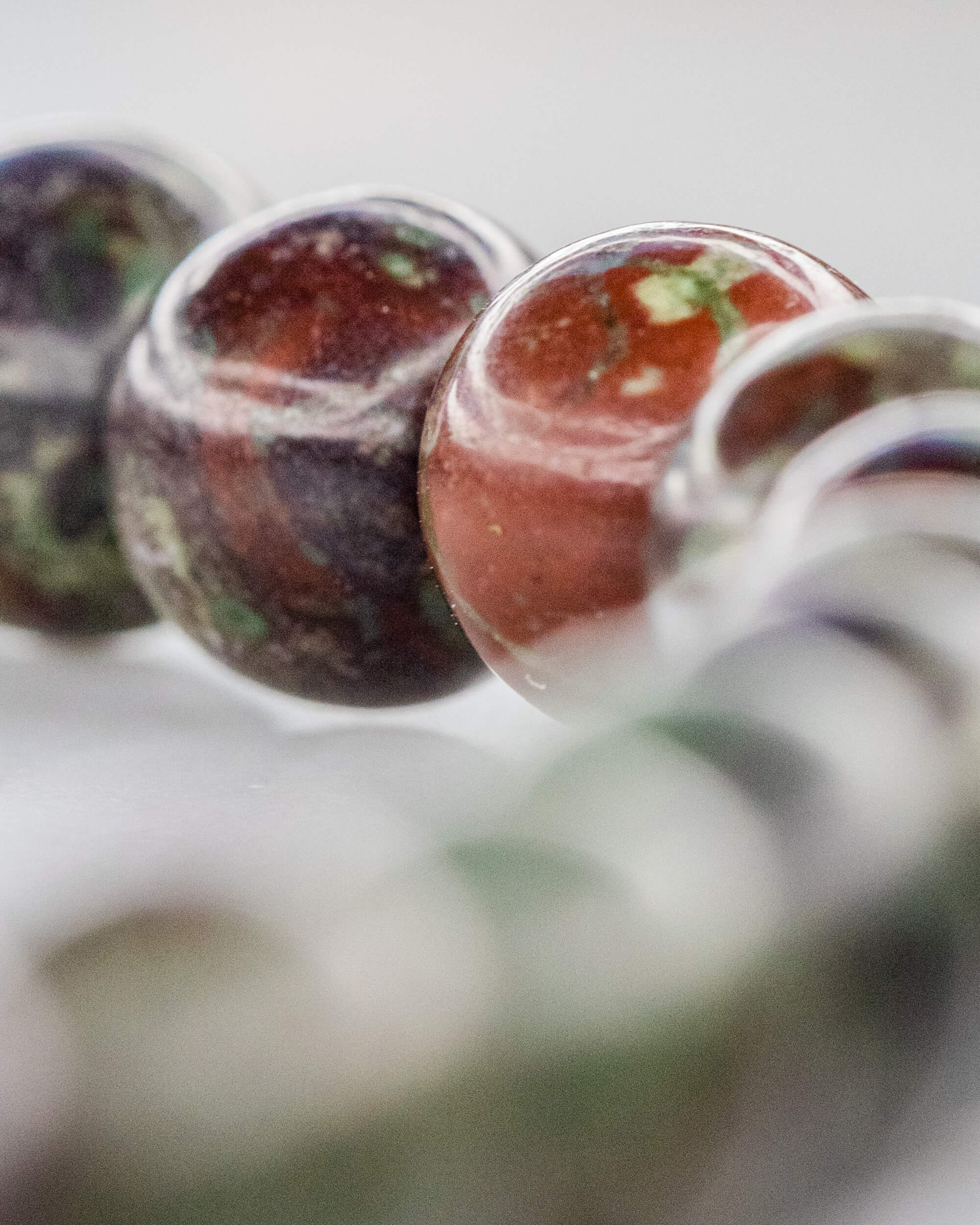 Detalle macro de cuentas de Jaspe Sangre de Dragón con motas verdes sobre rojo oscuro