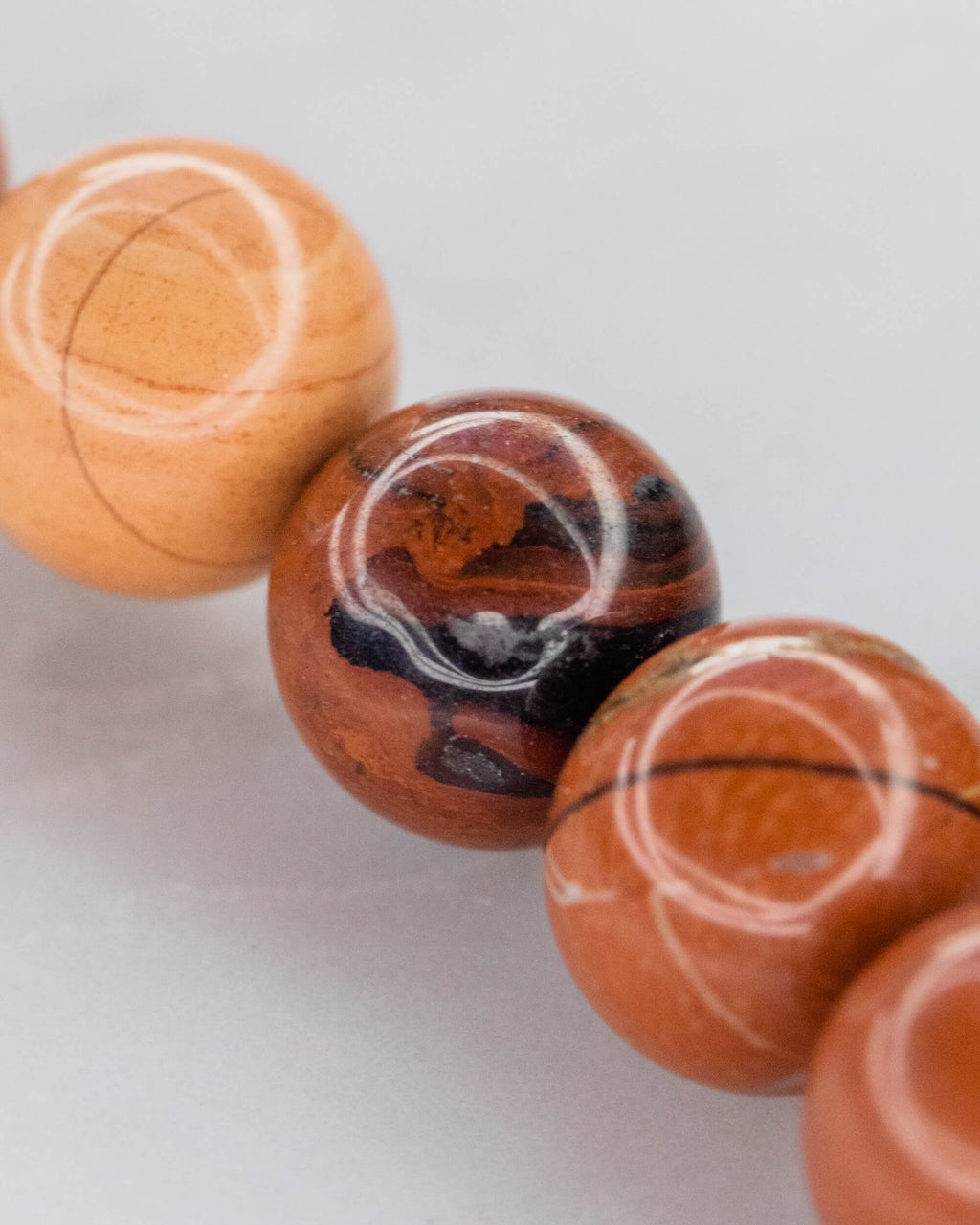 Detalle macro de cuentas de Jaspe Rojo en distintos tonos anaranjados y cafes