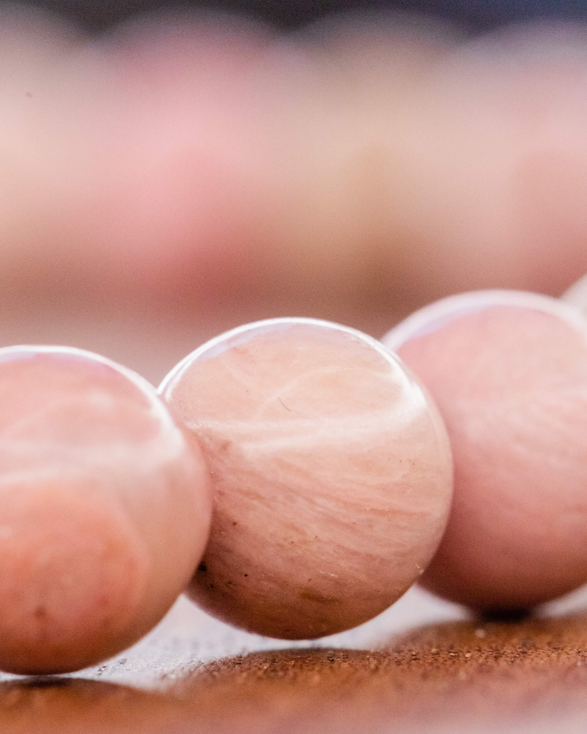 Detalle macro de cuentas redondas de Rodonita Rosa en tono claro