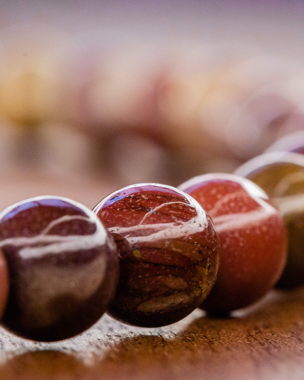 Detalle macro de cuentas de Jaspe Mokaita en tonos vino y rojizo