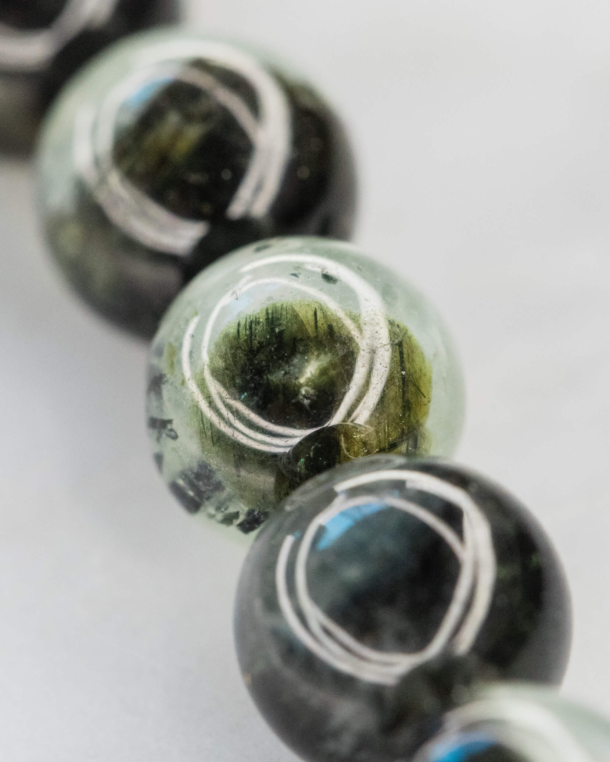 Detalle macro de las cuentas de Prehnita con vetas verdes y negras