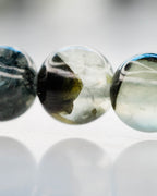 Detalle macro de las cuentas de Prehnita con vetas negras y transparencias