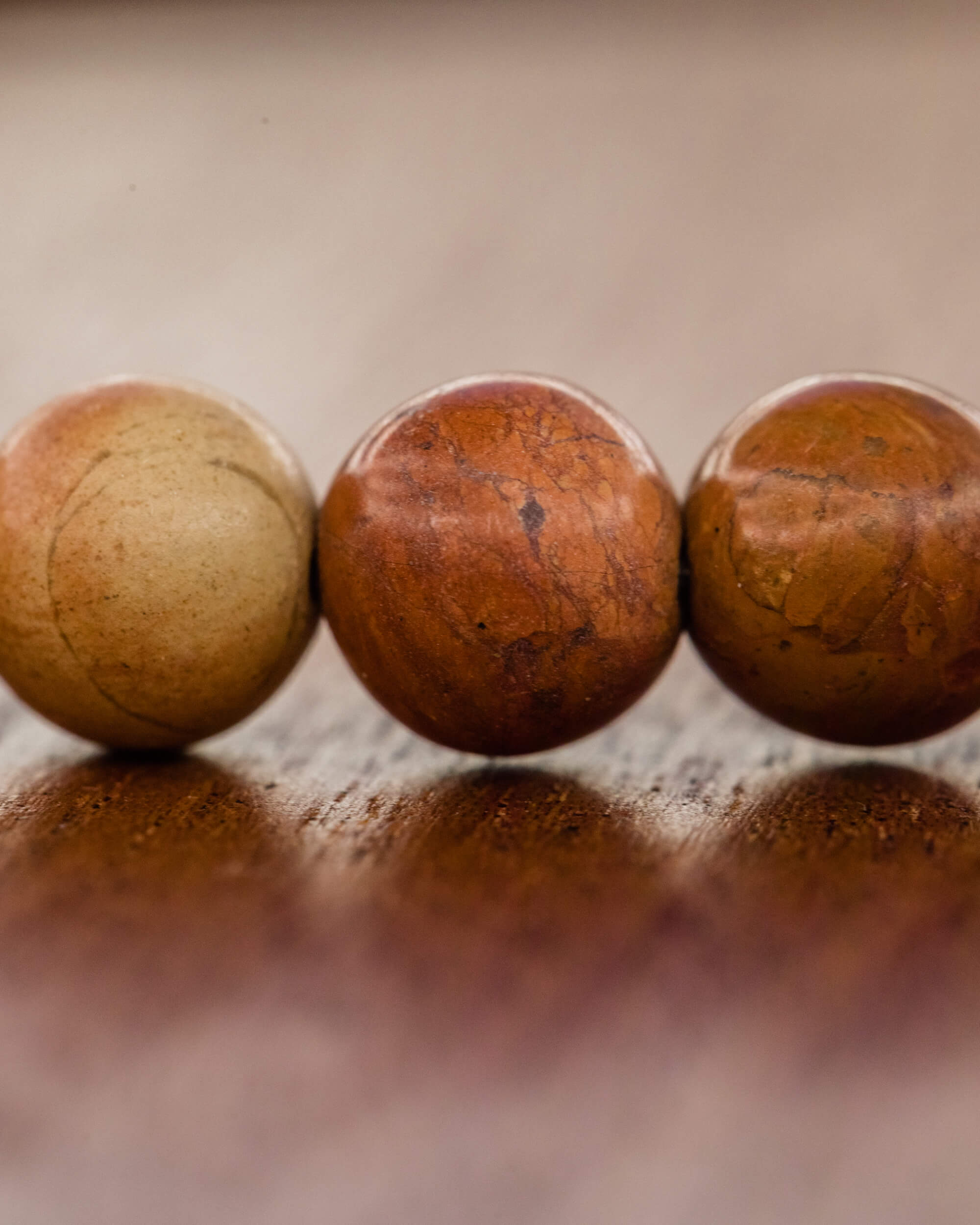 Detalle macro de tres cuentas del Codificador en tonos beige y terracota