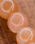 Detalle macro de las cuentas de Piedra Sol Naranja con destellos internos