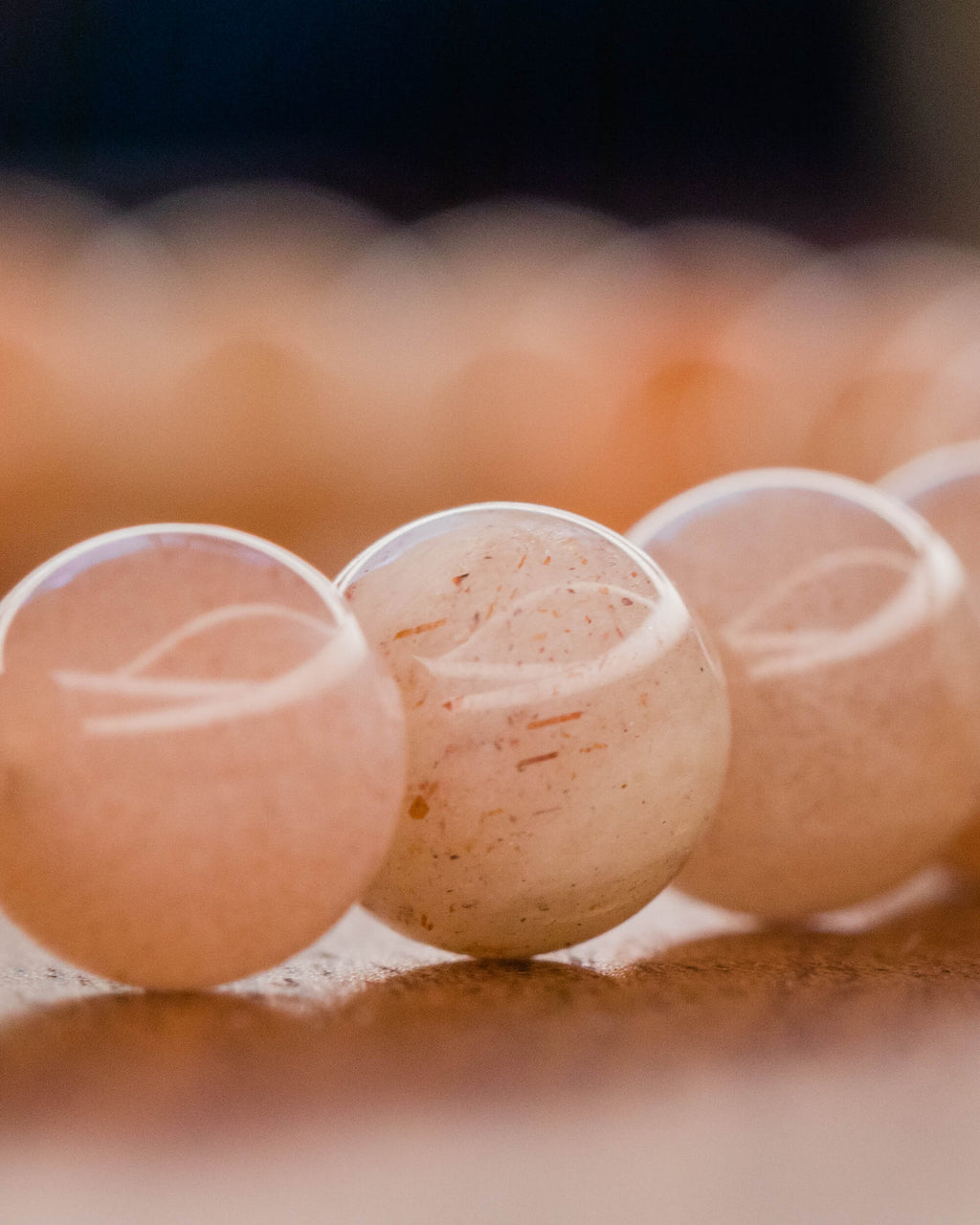 Detalle macro de las cuentas de Piedra Sol Naranja con vetas doradas