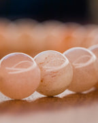Detalle macro de las cuentas de Piedra Sol Naranja con vetas doradas