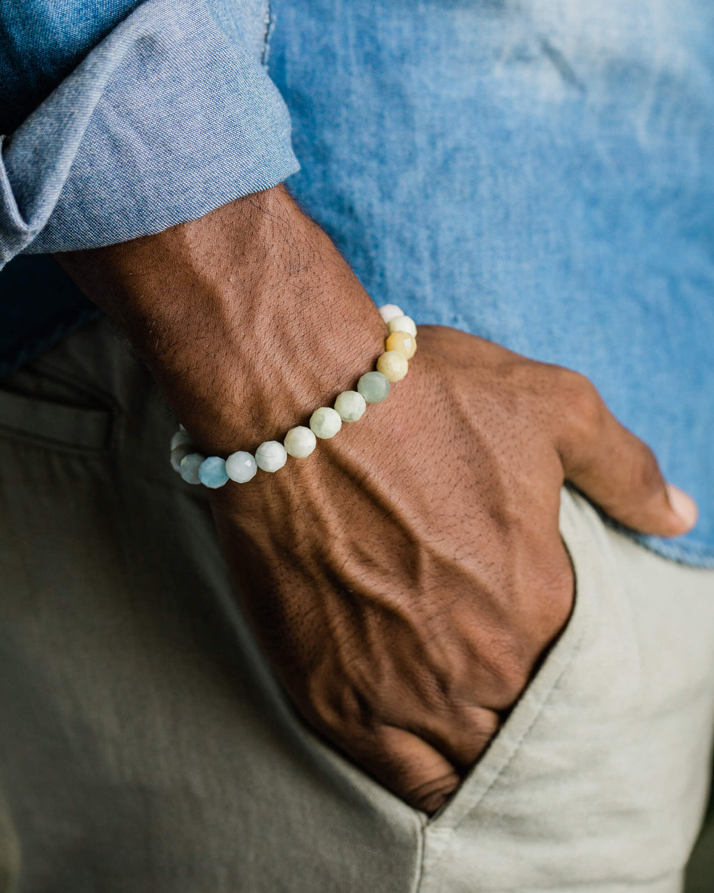 Pulsera de Berilos facetados puesta en muñeca, mano en bolsillo de pantalon