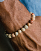 Pulsera de Shoushan puesta en la muñeca, con camisa azul de fondo