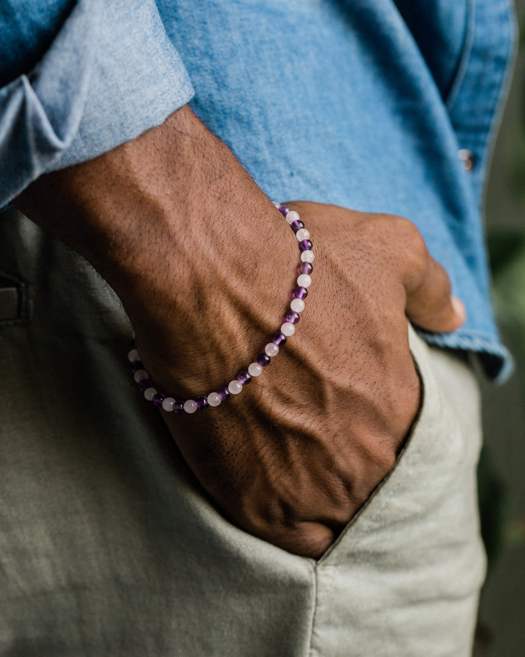 Pulsera de Amatista y Cuarzo Rosa puesta en la muñeca, mano dentro del bolsillo del pantalon