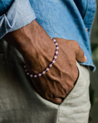 Pulsera de Amatista y Cuarzo Rosa puesta en la muñeca, mano dentro del bolsillo del pantalon