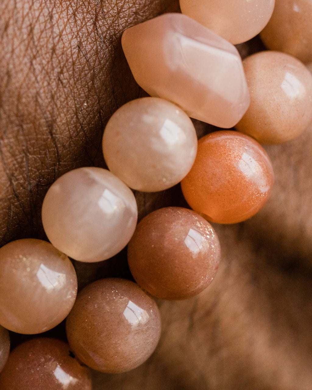 Codificador de Piedra Sol Naranja puesto en la muñeca, cuentas en tonos naranja y crema