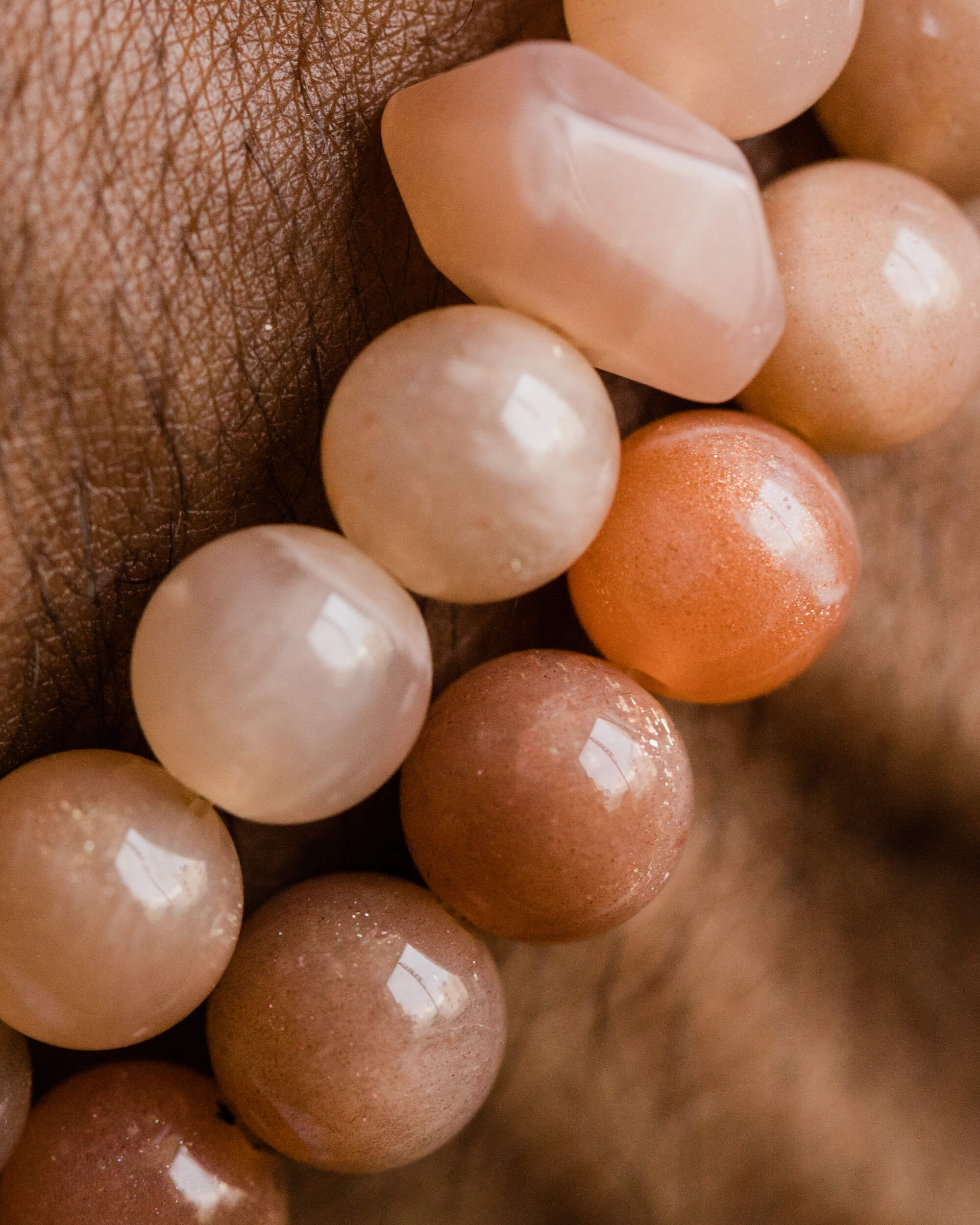 Codificador de Piedra Sol Naranja puesto en la muñeca, cuentas en tonos naranja y crema