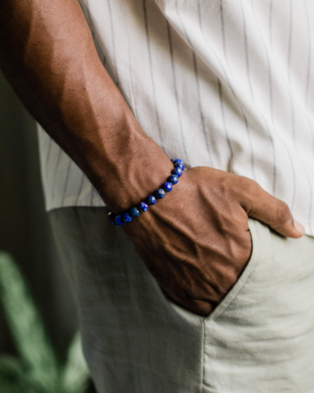 Pulsera de Lapislázuli puesta en la muñeca, con el brazo apoyado en el bolsillo