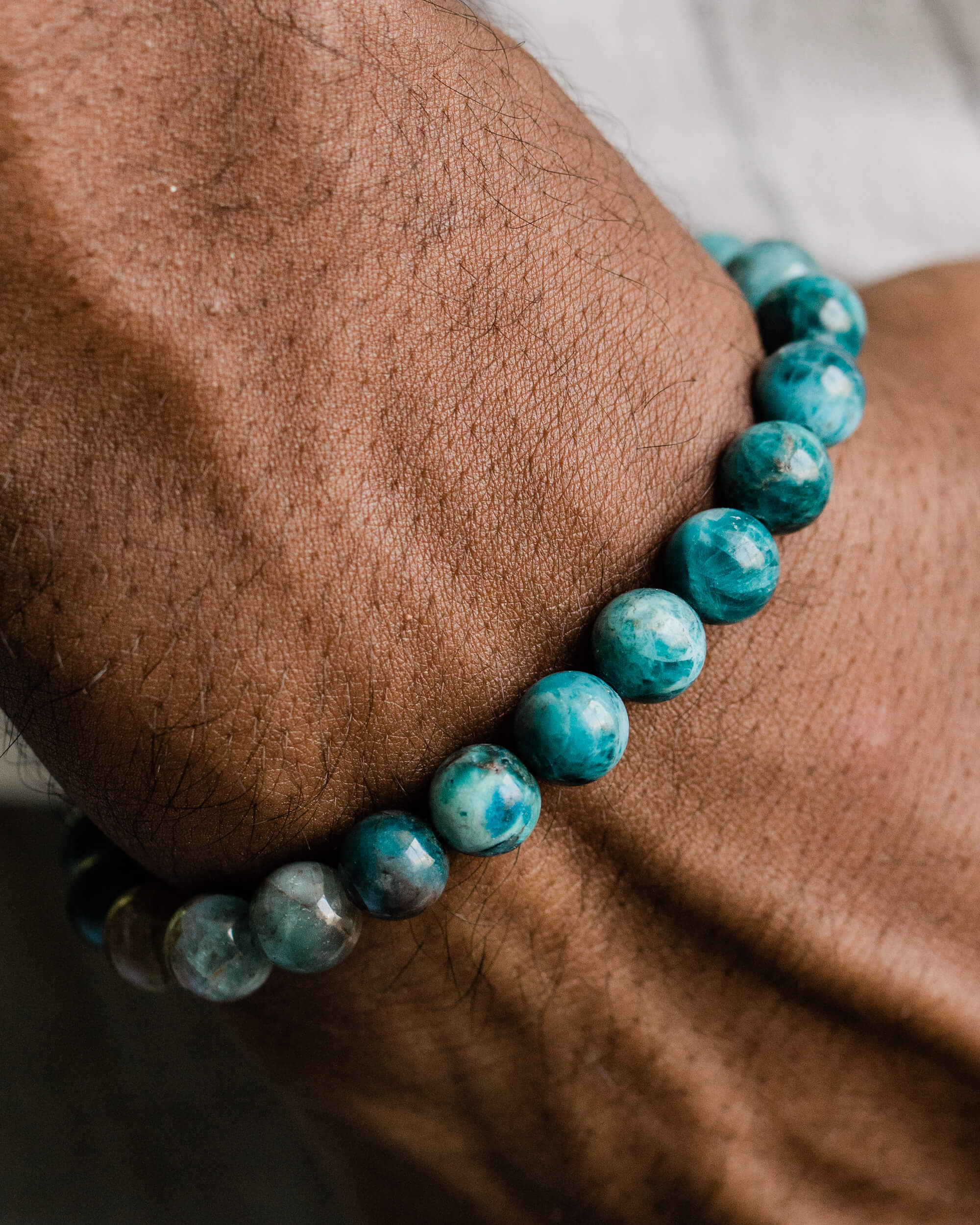 Pulsera de Apatita Azul puesta en la muñeca, detalle cercano sobre la piel
