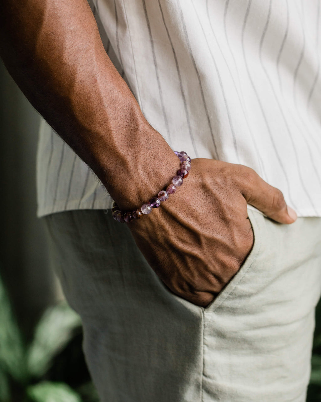 Pulsera de Amatista Fantasma puesta en la muñeca, con la mano en el bolsillo