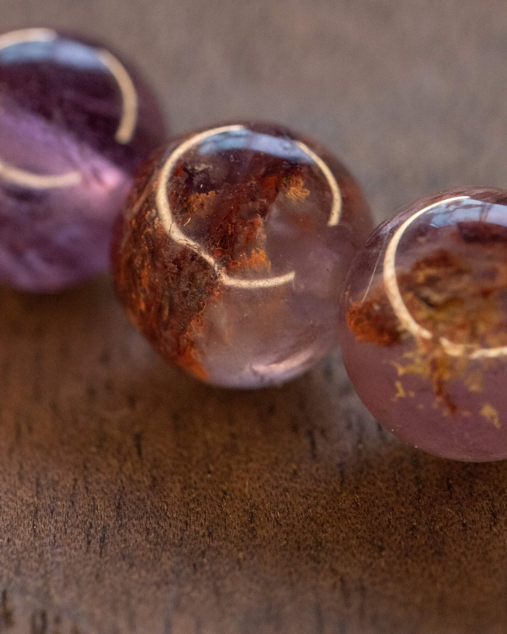Primer plano de las cuentas de Amatista Fantasma con vetas naranjas