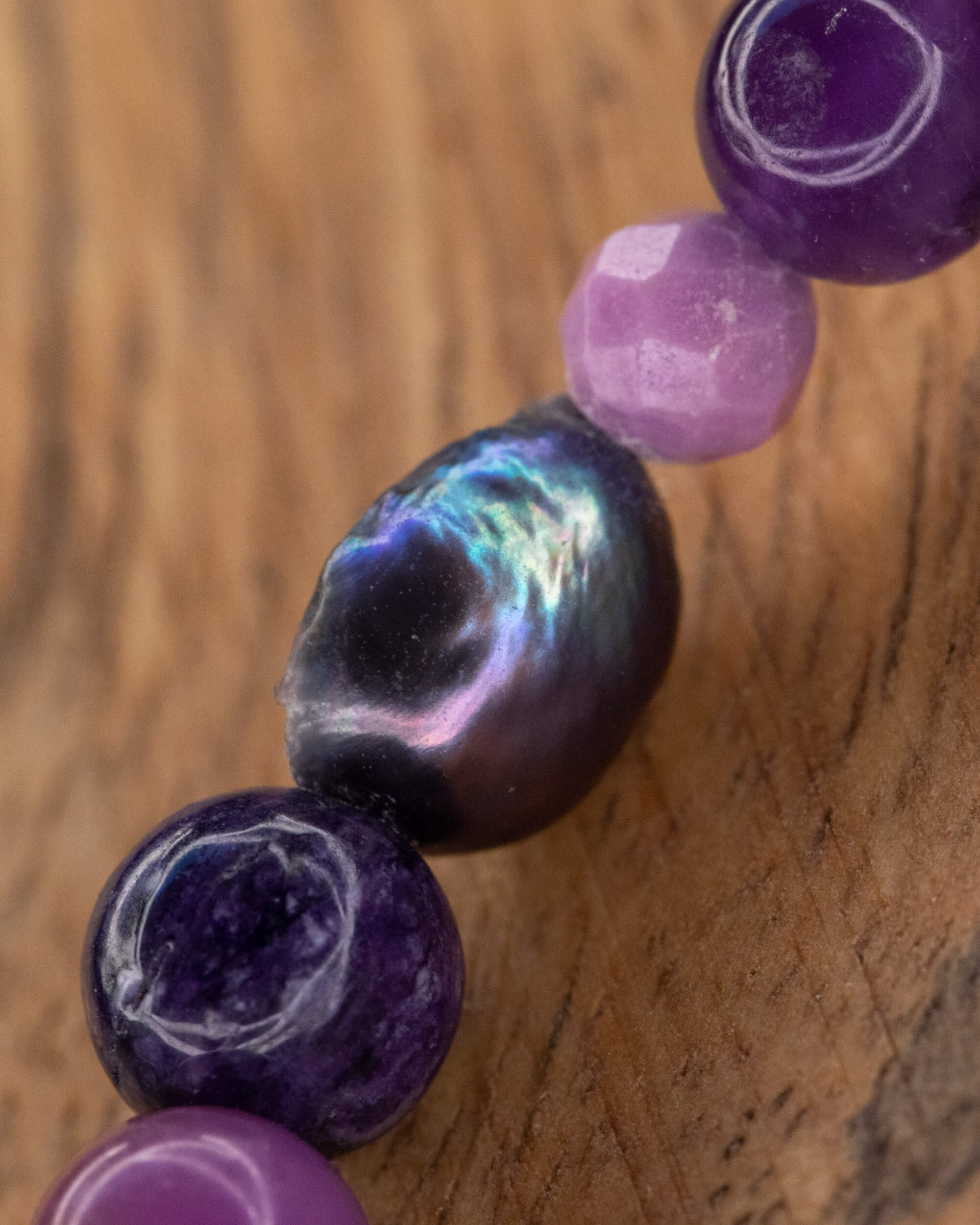 Detalle macro de la Perla Negra y cuentas de Amatista en la pulsera morada
