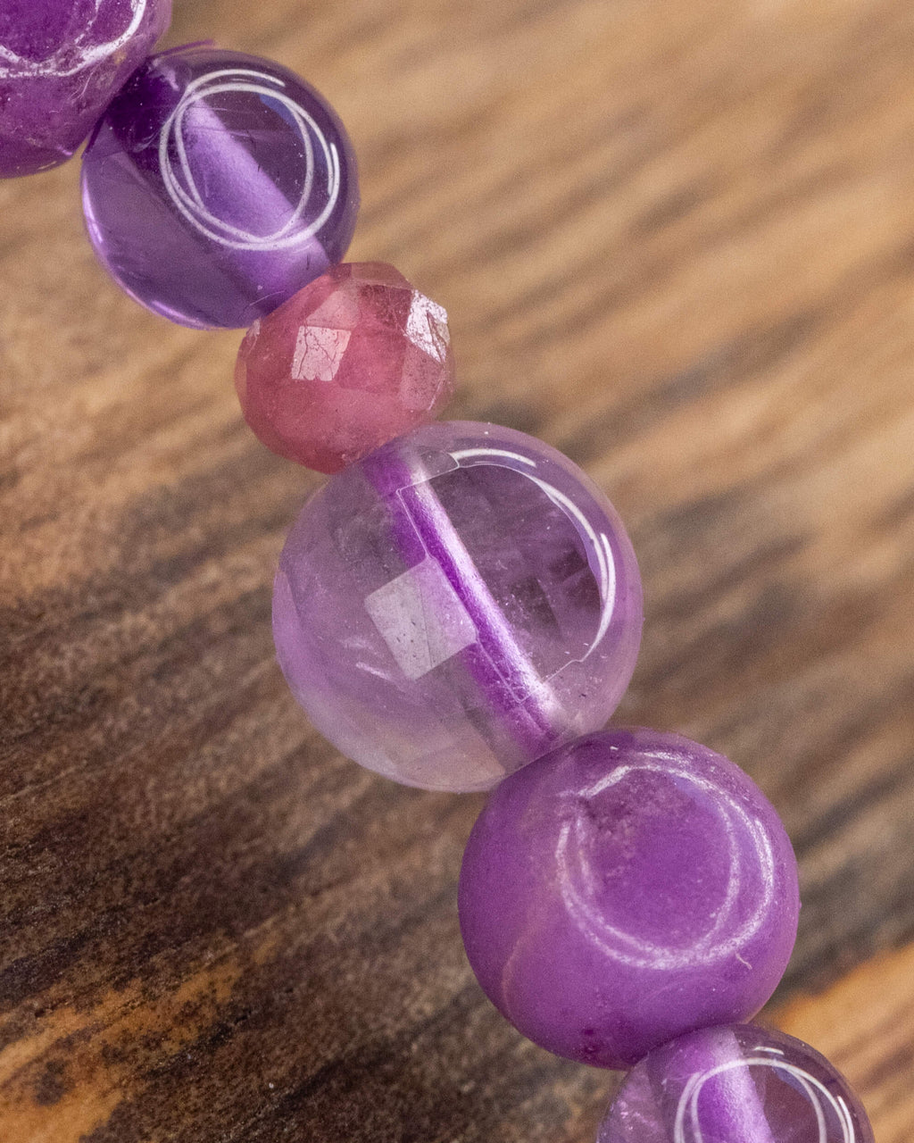 Detalle macro de la Amatista transparente entre cuentas moradas y lilas