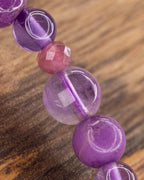 Detalle macro de la Amatista transparente entre cuentas moradas y lilas