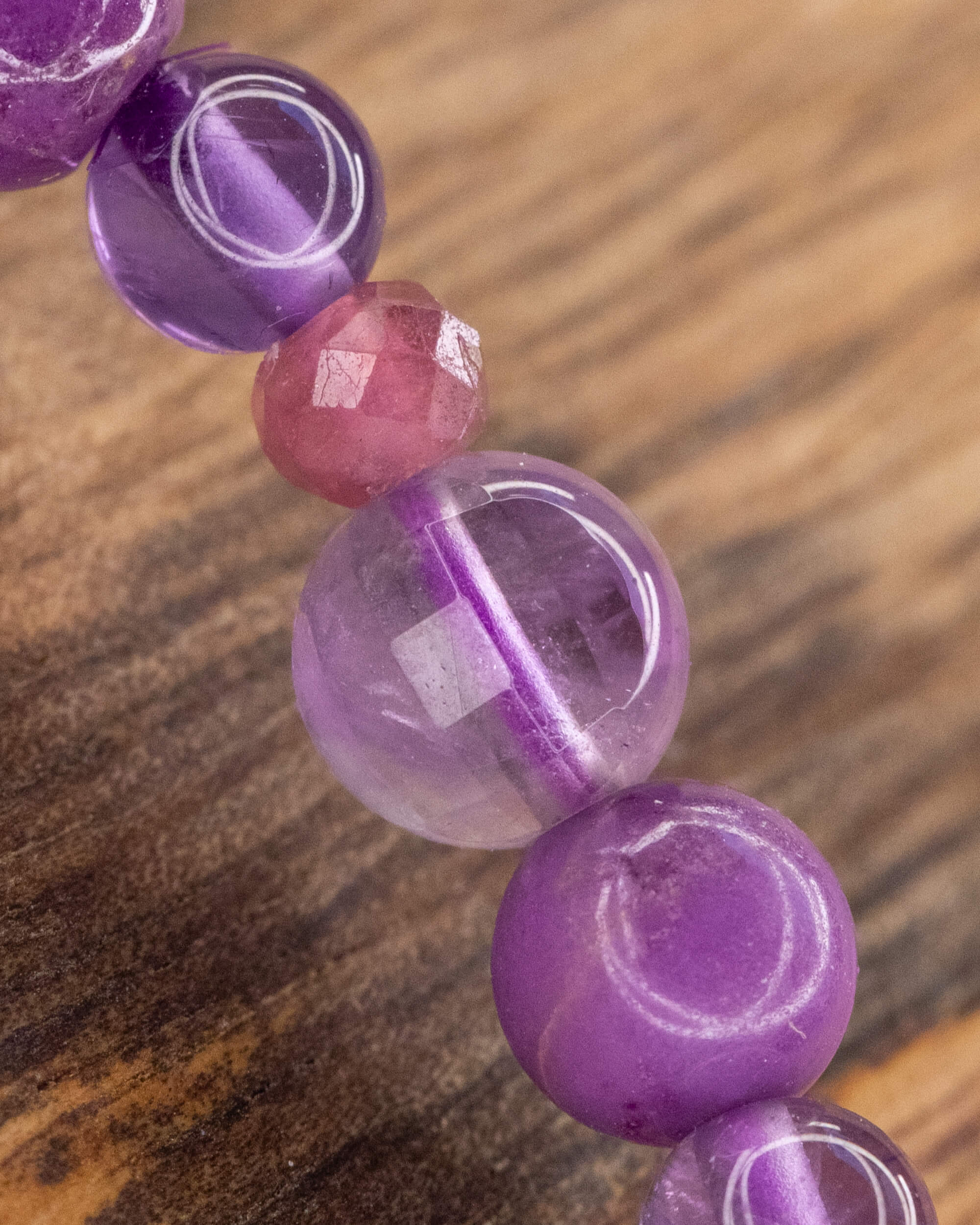 Detalle macro de la Amatista transparente entre cuentas moradas y lilas