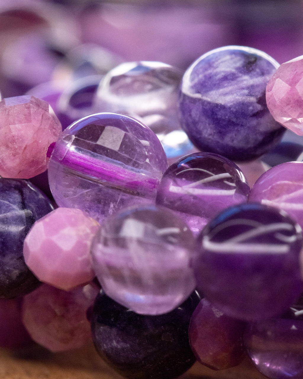 Detalle macro de la Amatista brillante entre cuentas moradas y rosa