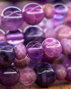 Detalle macro de las cuentas moradas y violeta apiladas en varias vueltas