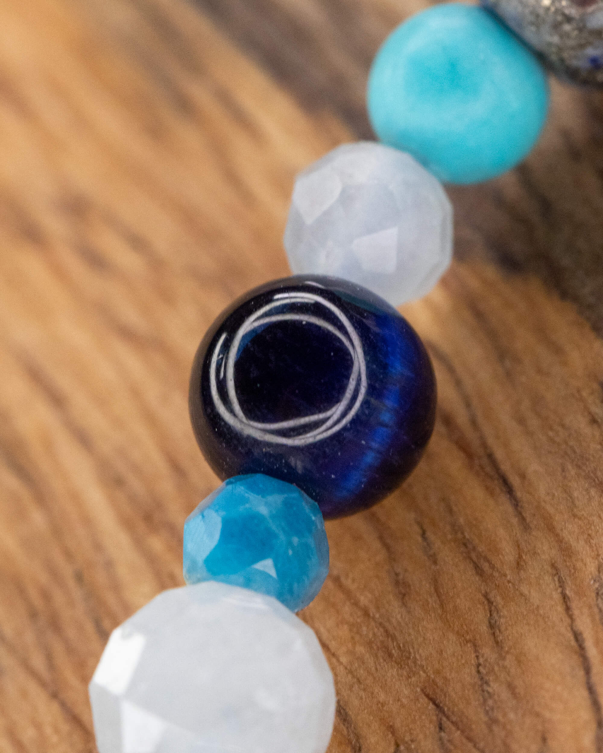 Detalle macro del Mix de Minerales Azules, cuenta de Ojo de Tigre Azul al centro