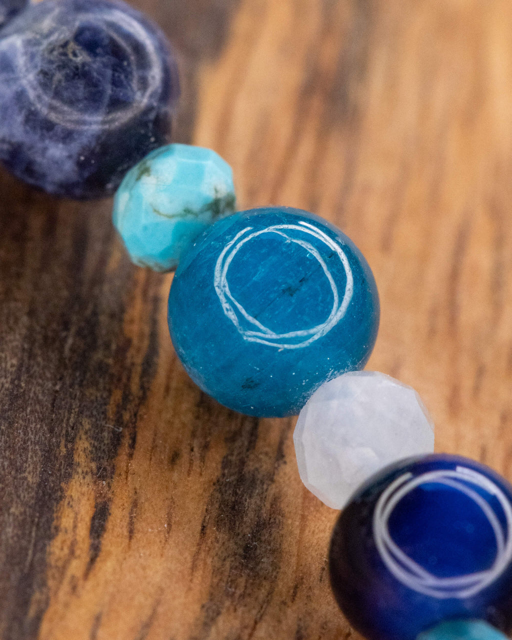 Detalle macro del Mix de Minerales Azules, Sodalita junto a Turquesa sobre madera