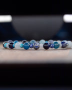 Pulsera Mix de Minerales Azules en fila, fondo oscuro con reflejos de luz