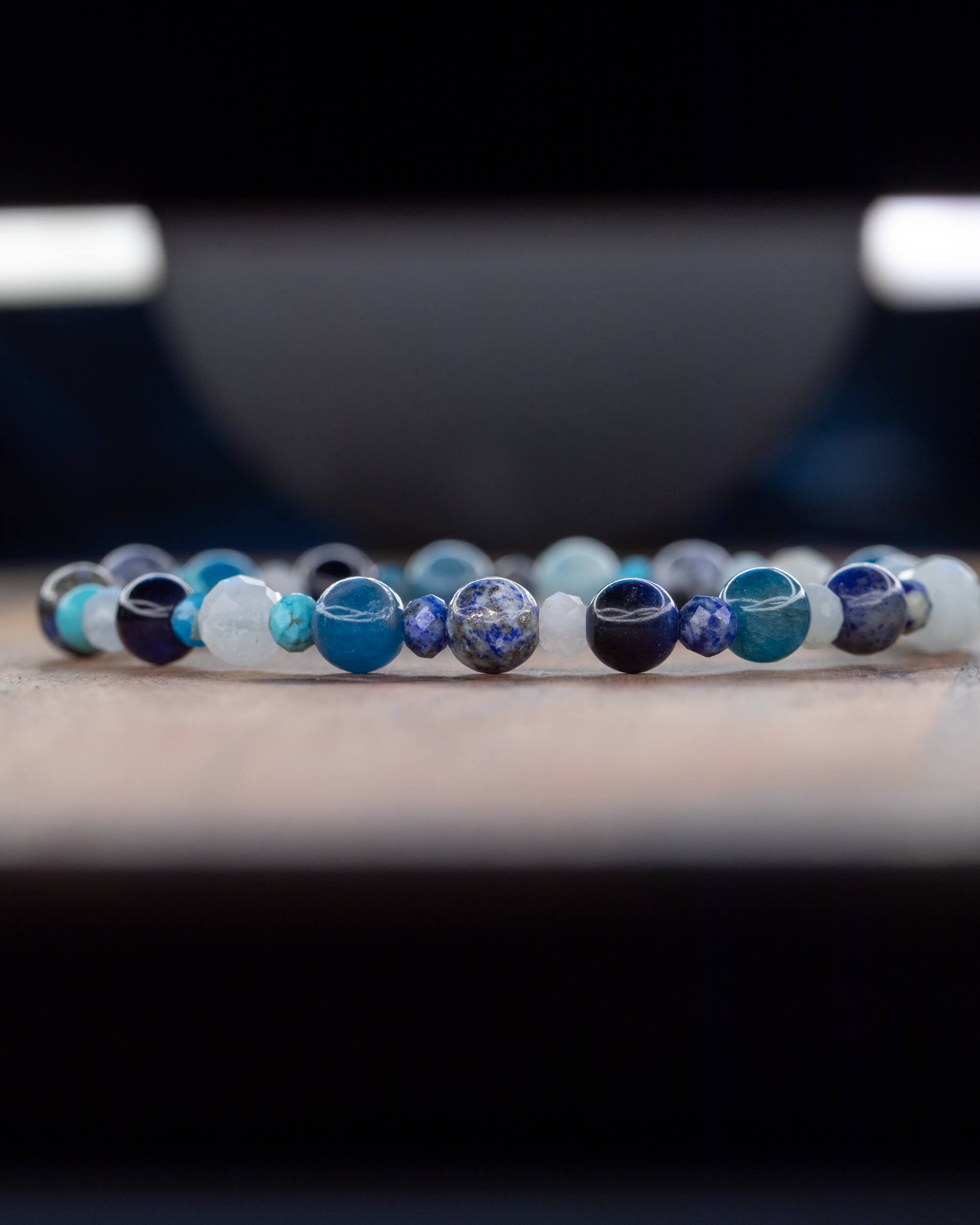 Pulsera Mix de Minerales Azules en fila, fondo oscuro con reflejos de luz
